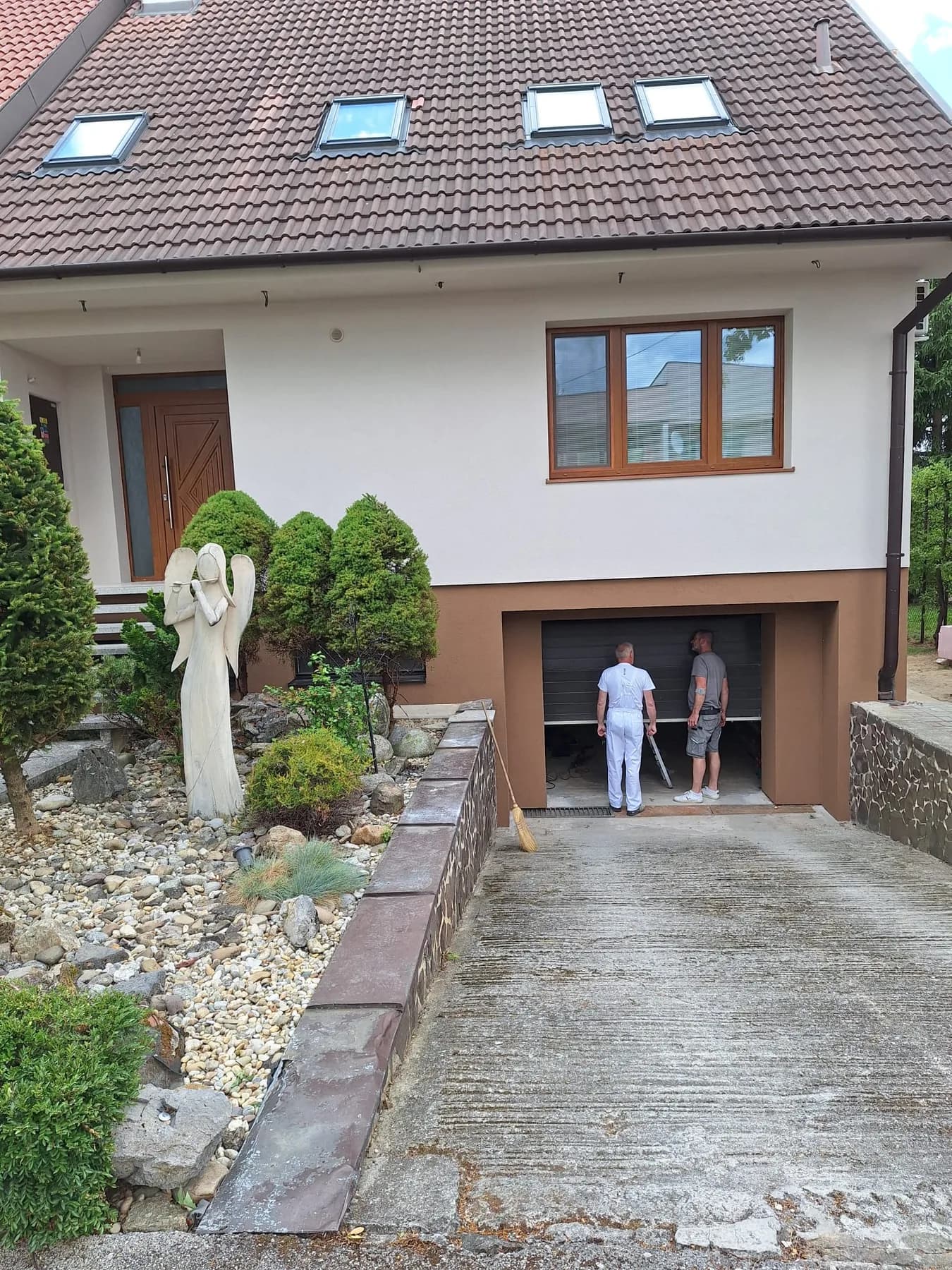 Ten istý rodinný dom po obnove s bielou fasádou a novým rámom garážového vstupu
