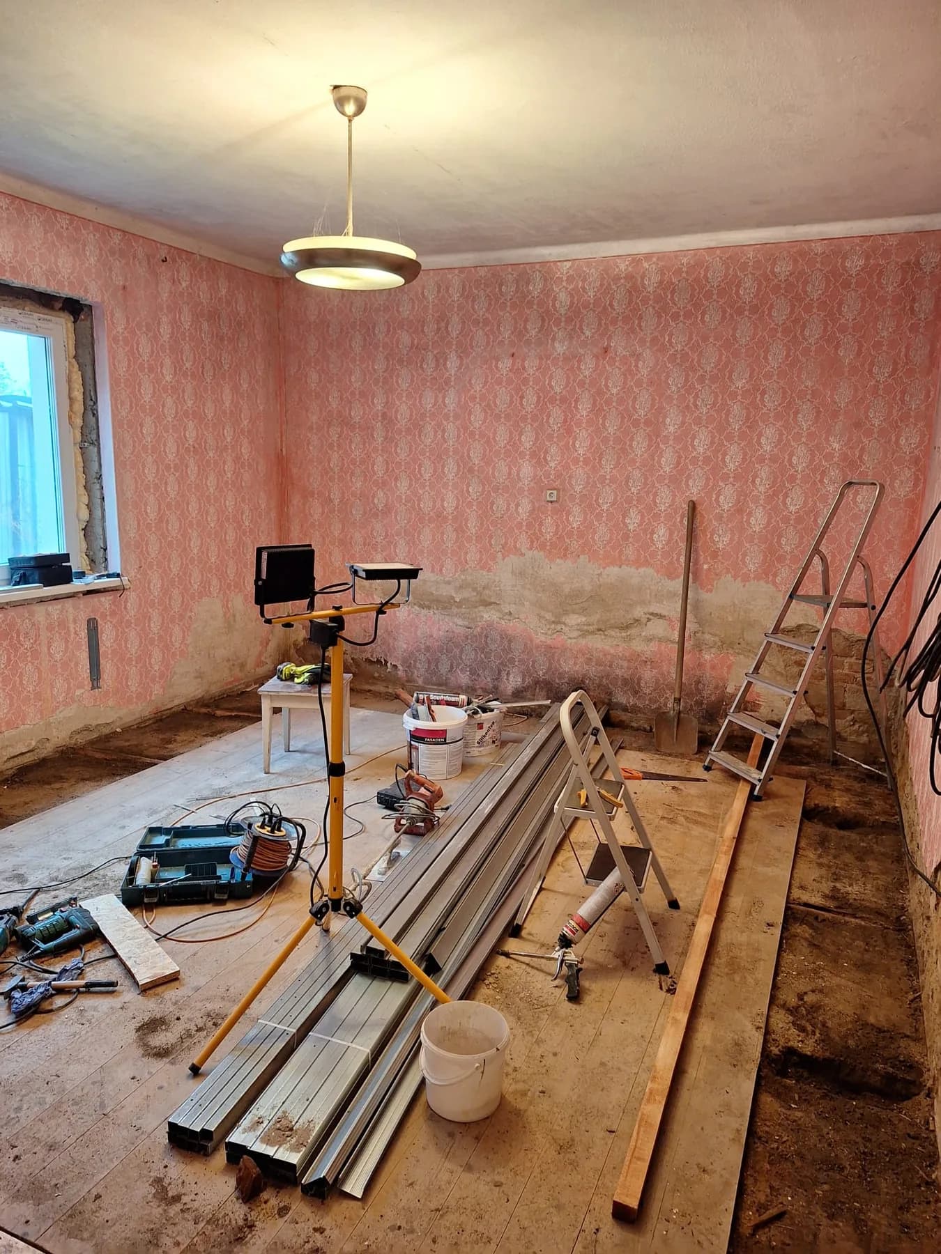 Izba pred rekonštrukciou so starými červenými stenami a odkrytým murivom